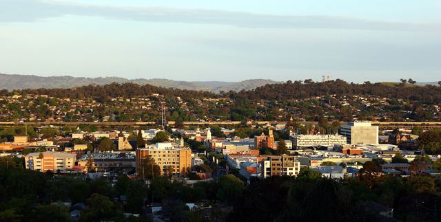 Albury's city centre and clock towers in golden evening light, seen from Monument Hill.