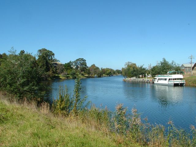 The Mitchell River at Bairnsdale with a white river cruise boat moored at a jetty.