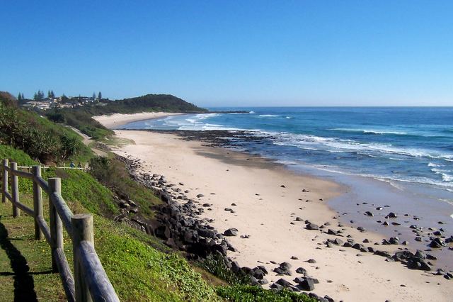 Shelly Beach at East Ballina seen from the lighthouse lookout, with dark rocks, white sand and surf.