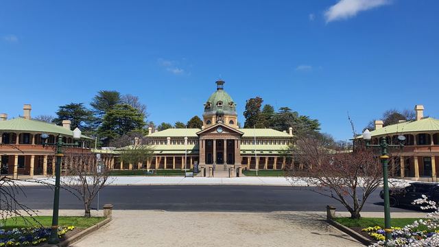 Bathurst's domed sandstone-and-brick Court House across the street from spring flower beds.