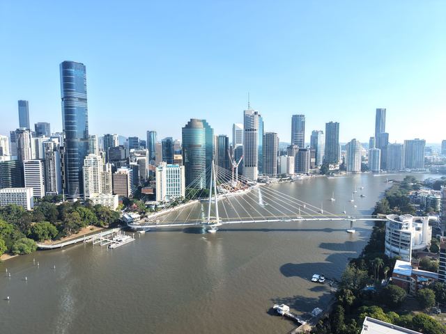 Aerial view of the Brisbane CBD skyline wrapped by the Brisbane River on a sunny day.