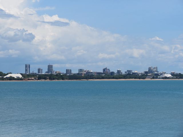 Darwin city skyline seen across the water from East Point under a tropical sky.