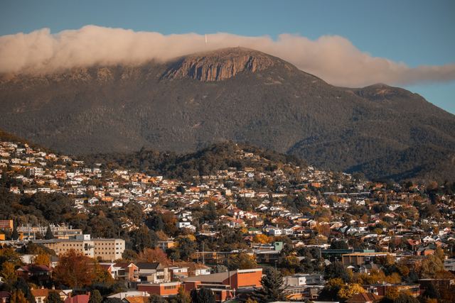 Hobart's hillside suburbs below kunanyi / Mount Wellington with cloud over the summit.