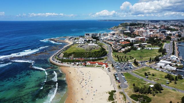 Aerial view of Nobbys Beach, Fort Scratchley and the Newcastle city centre on a sunny day.