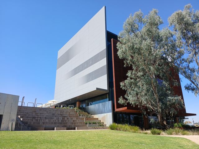 The modern Shepparton Art Museum building beside gum trees under a blue sky.