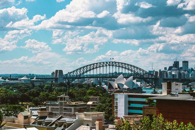 Sydney Harbour Bridge and the Sydney Opera House across the harbour on a sunny day.