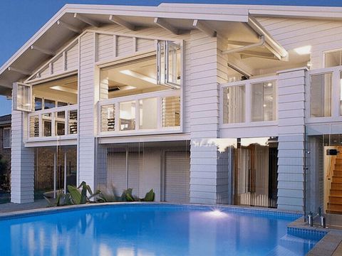 The same renovation at dusk, with the pool and outdoor lights on