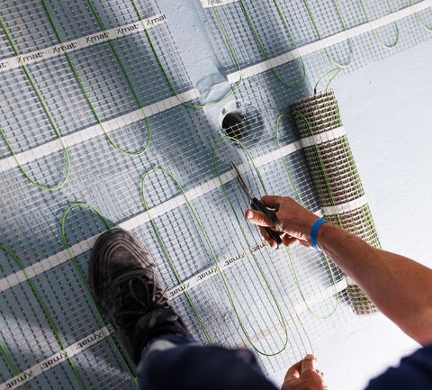 Trimming the mat's mesh to fit around the floor waste